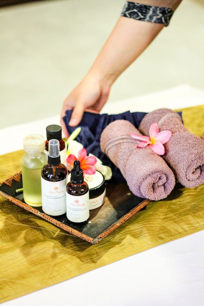 Tray with spa essentials including oils, towels, and flowers for a relaxing spa experience.